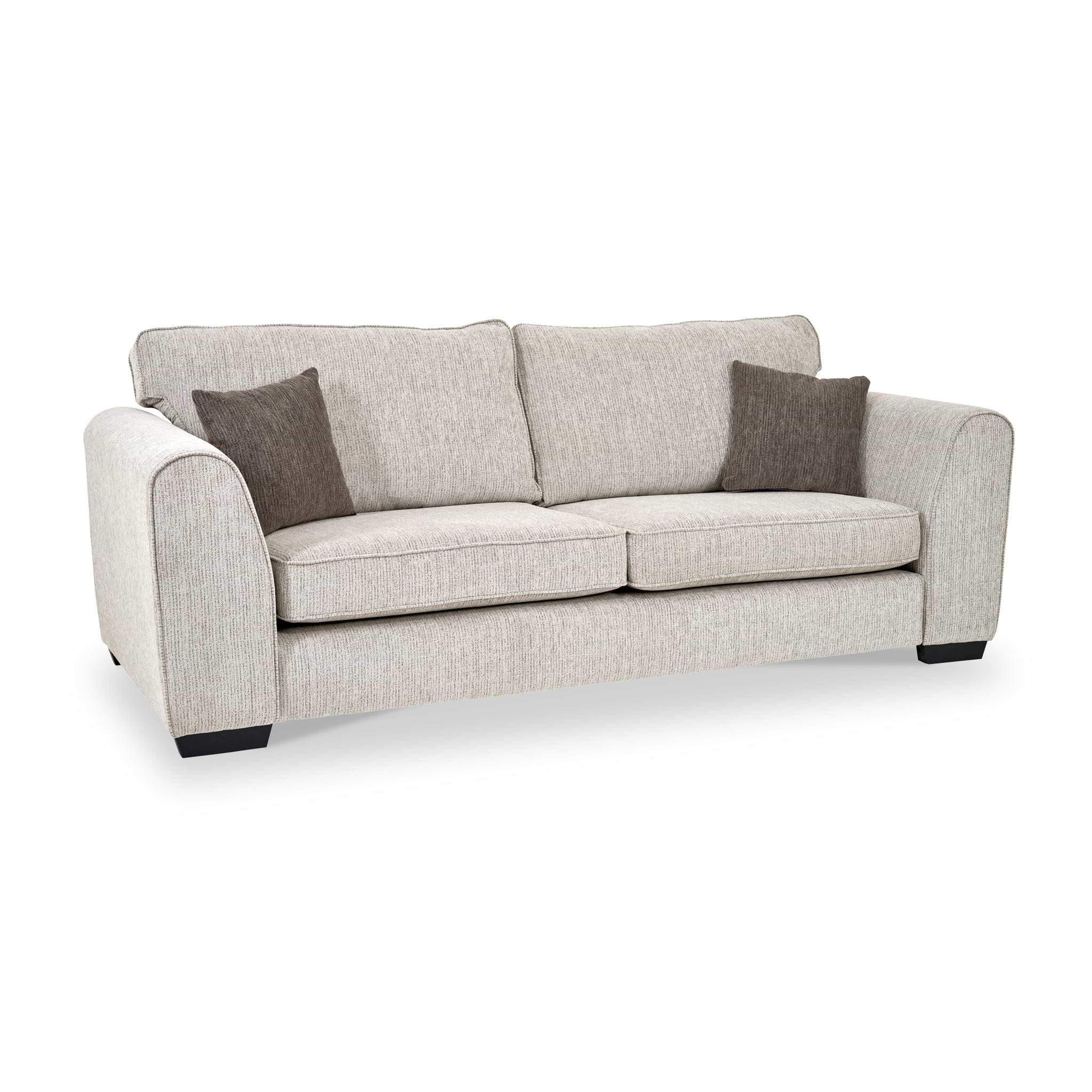 Thornby 4 Seater Sofa Natural Mink from Roseland Furniture postitioned at an angle highlighting the black legs and textured details of the sofa with simple piping around the edges and two Brown cushions.