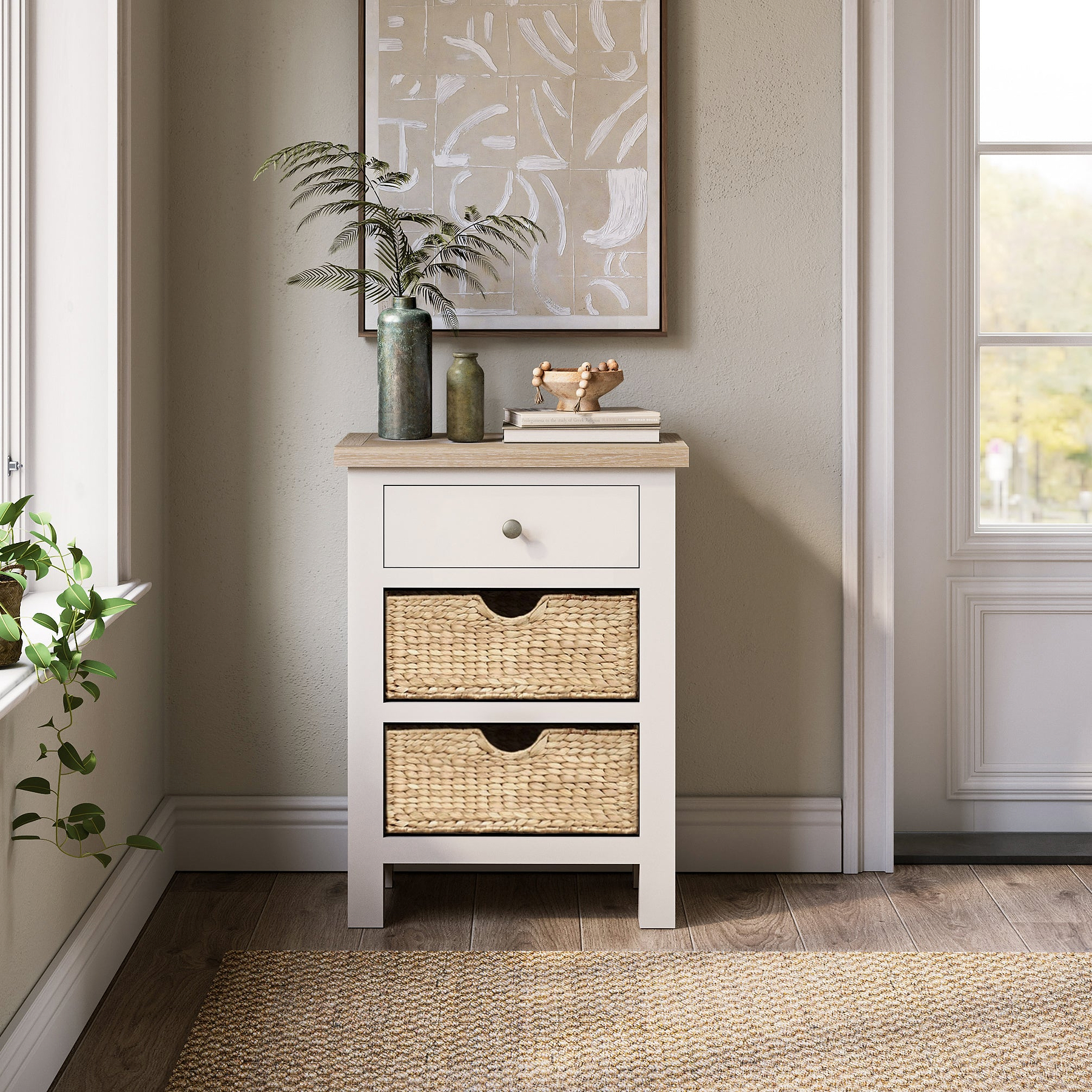 Farrow Basket Side Table from Roseland Furniture decorated with books, pictures, and vases in a room

