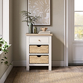 Farrow Basket Side Table from Roseland Furniture decorated with books, pictures, and vases in a room