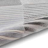 A stack of woven textiles with varying shades of grey and white, creating a gradient effect from light to dark, displayed against a neutral background.