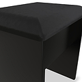 A modern, black ottoman with a textured fabric surface and simplistic design is present, isolated on a white background.