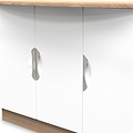 Two reflective cabinet knobs on a white door panel, positioned symmetrically, with a wooden countertop overhead.