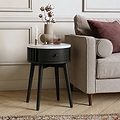 A modern Shorwell Black & Marble 1 Drawer Side Table with a white marble top and a dark charcoal black drawer and legs, styled next to a beige armchair in a living room setting.