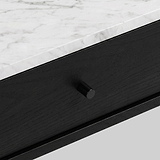Close-up of a modern Shorwell Black & Marble 1 Drawer Oval Coffee Table drawer with a black wood finish and a small round black knob, set beneath a white marble top with gray veining.