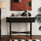 A modern Shorwell Black & Marble Oval Console Table  with a black slatted frame, white marble top, and black legs, styled in a living room setting with books, a candle, and decorative rocks.