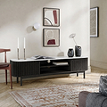 A modern Shorwell Black & Marble Slatted 180cm TV Unit in a styled living room setting, featuring a white marble-look top, a black ribbed cabinet body, and open shelving.