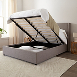 Brent Ottoman Storage Bed Frame from Roseland Furniture- Gray upholstered bed with raised headboard in a bedroom setting
