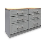 A grey wooden dresser with six drawers and silver handles, topped with a light wood surface, isolated on a white background.
