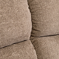 Stacked beige cushions with a textured fabric, closely arranged without any discernible action, in an indistinct neutral-colored setting.