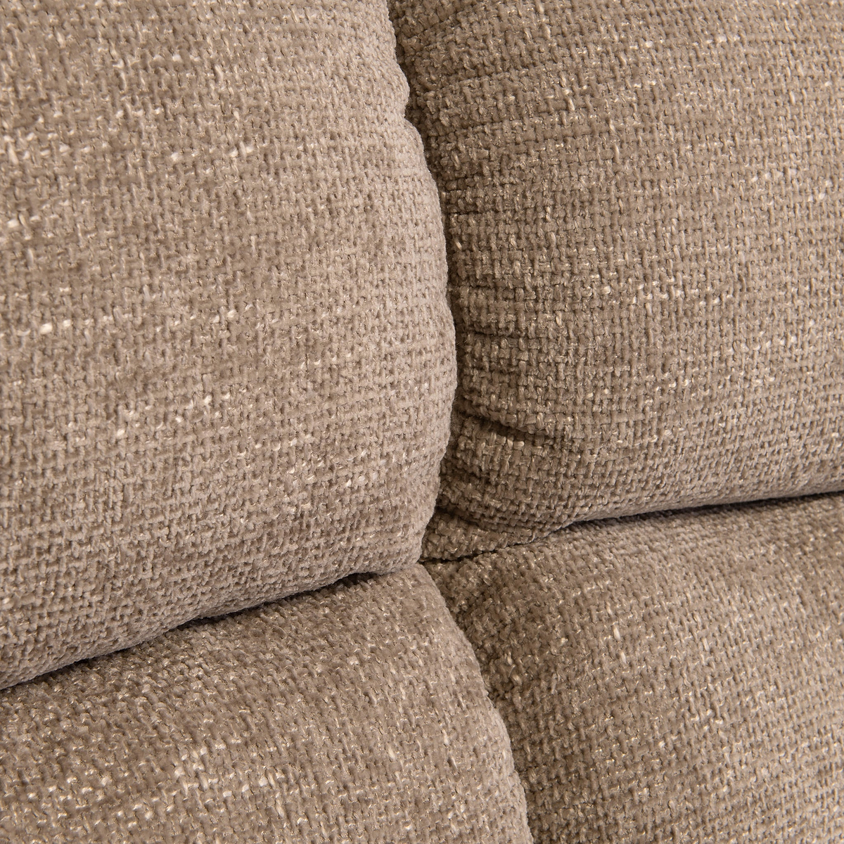 Stacked beige cushions with a textured fabric, closely arranged without any discernible action, in an indistinct neutral-colored setting.