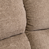 Stacked beige cushions with a textured fabric, closely arranged without any discernible action, in an indistinct neutral-colored setting.