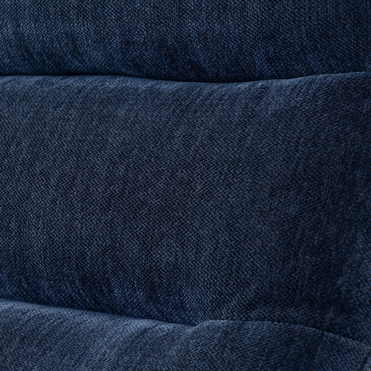 Textured denim fabric arranged with visible folds, giving a visual sense of softness and flexibility, typically associated with clothing material.