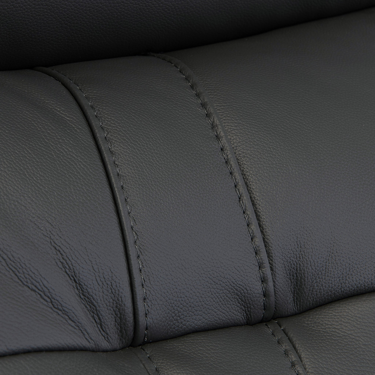 Black leather texture with visible stitching detail, creating a pattern of upholstered segments; likely from furniture such as a couch or car seat.