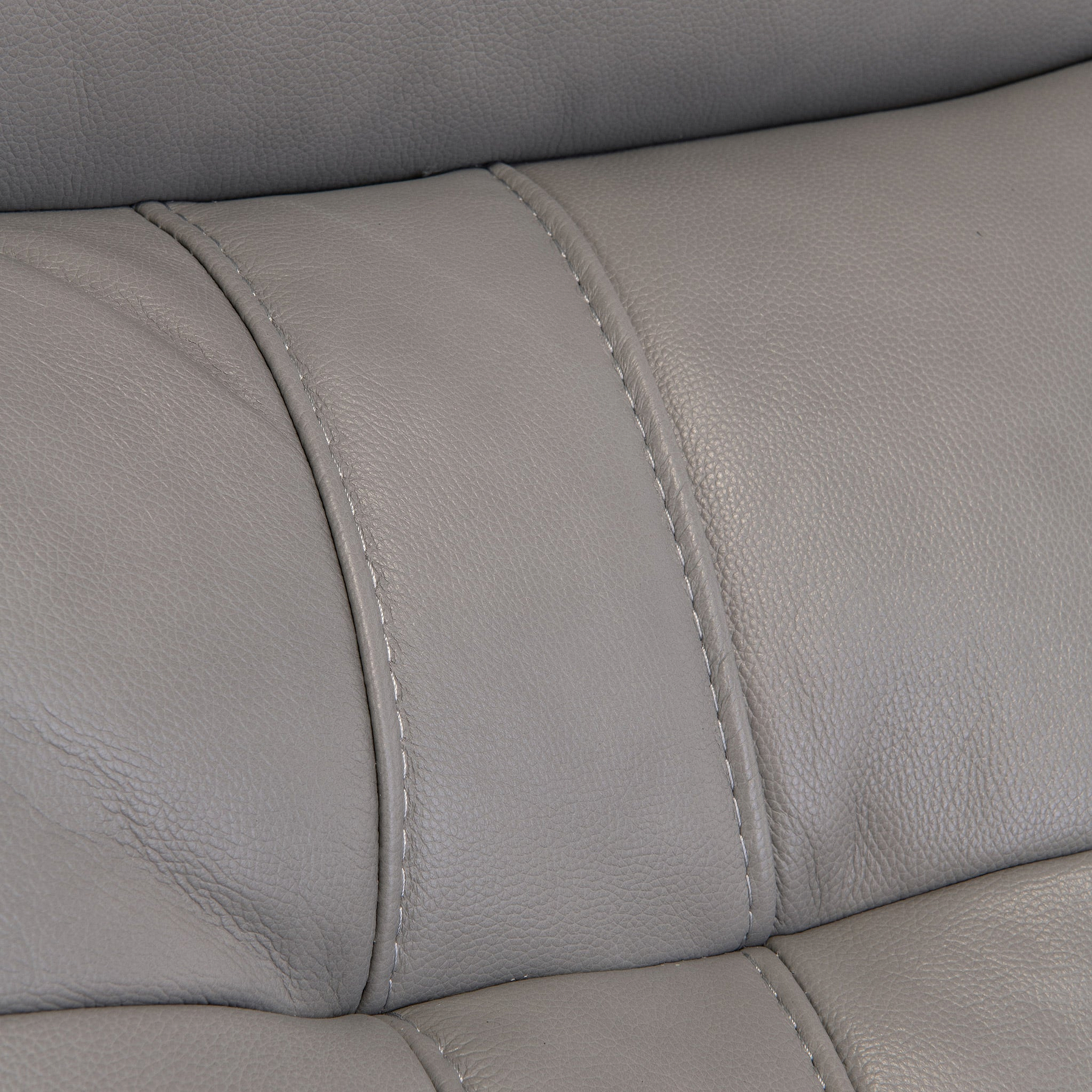 Close-up of a gray leather surface with stitching, possibly part of furniture like a sofa or chair, with no discernible action or context.