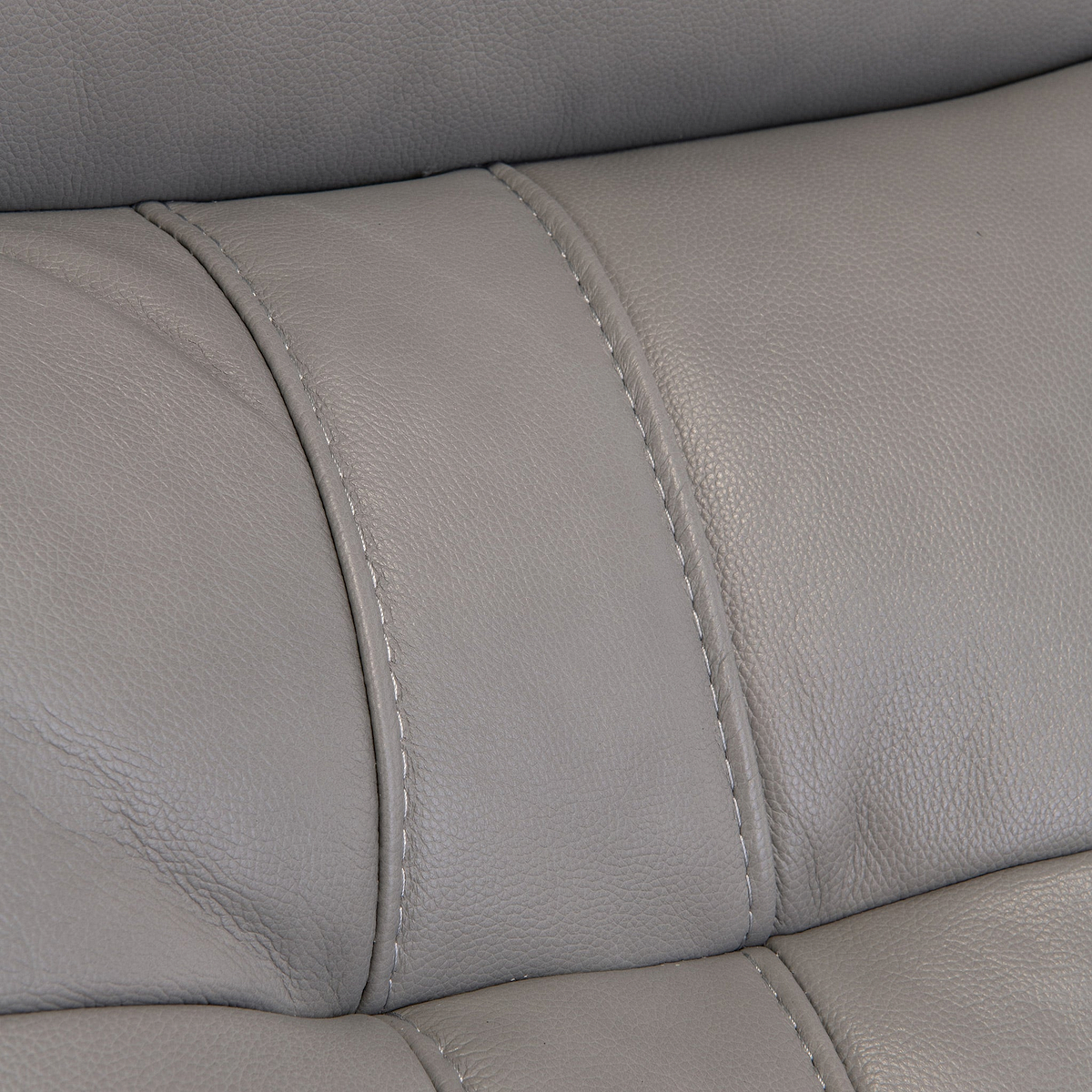 A close-up of a grey leather sofa section showing texture and stitching details.