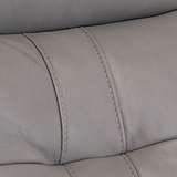 A close-up of a grey leather sofa section showing texture and stitching details.