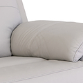 Beige leather sofa with a cylindrical cushion resting on its seat against a white background.