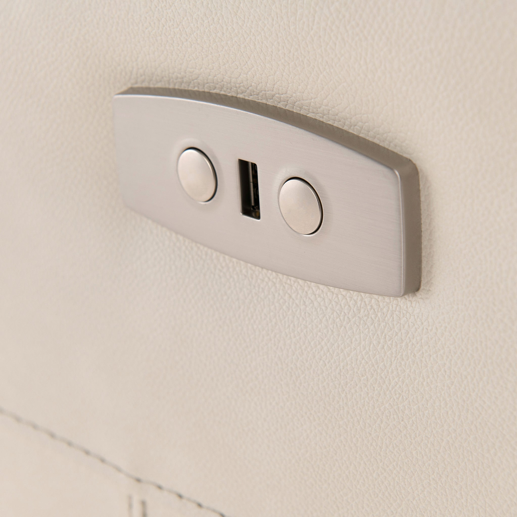 A dual USB port is mounted on a textured beige wall, providing a charging point in a modern interior setting.