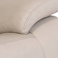 Close-up of a beige leather sofa showing stitching detail, texture, and cushioning, reflective of comfort and modern interior design.