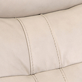 Close-up of a beige leather surface with visible stitching, likely a part of furniture such as a sofa or chair.