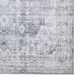 A vintage-style rug with intricate patterns and faded colors, predominantly in shades of gray and beige, rests against a white backdrop.