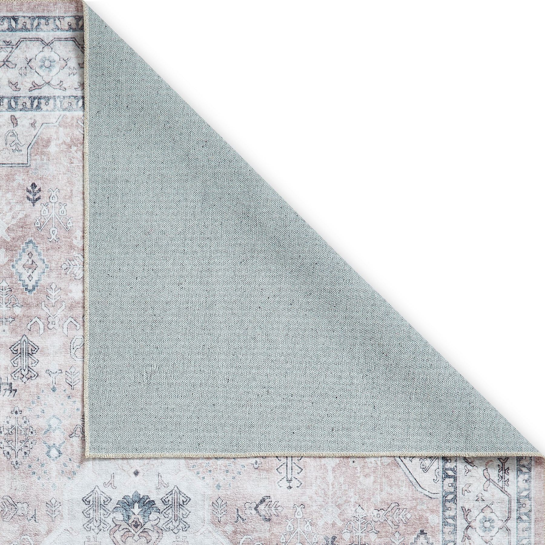 A patterned rug partially overlaps with a plain rug, creating a diagonal line of contrast, on a simple white background.