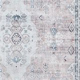 A patterned rug exhibits intricate designs with varied shapes and symbols in muted blues and beiges, emphasizing traditional textile art.