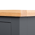 A wooden surface with a sanded corner rests atop a dark cabinet against a grey background.