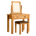 A wooden vanity table with an upright mirror and two drawers, accompanied by a matching stool with a brown cushion, isolated on a white background.