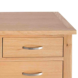 A wooden bedside table with two closed drawers featuring metal handles, set against a plain white background.