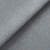 Blue textured fabric folded to create a shadow across the surface, presenting a close-up view of textile detail.