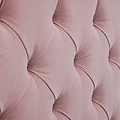 A close-up of a pink, tufted fabric forming a diamond pattern with visible stitching and shadows accentuating its plush texture.