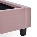 A pink upholstered ottoman with an open black interior and a single black leg visible, isolated on a white background.