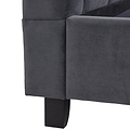 A close-up of a dark grey sofa corner with a visible black leg against a white background.