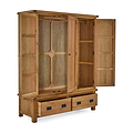 A wooden wardrobe stands open, displaying its empty shelves and drawers, isolated against a plain background.