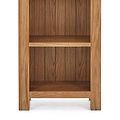 Zelah Oak Narrow Bookcase - Close up of lower shelves and feet on bookcase