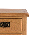A wooden side table with a flat top and a drawer featuring a brass half-moon pull handle, against a plain white background.