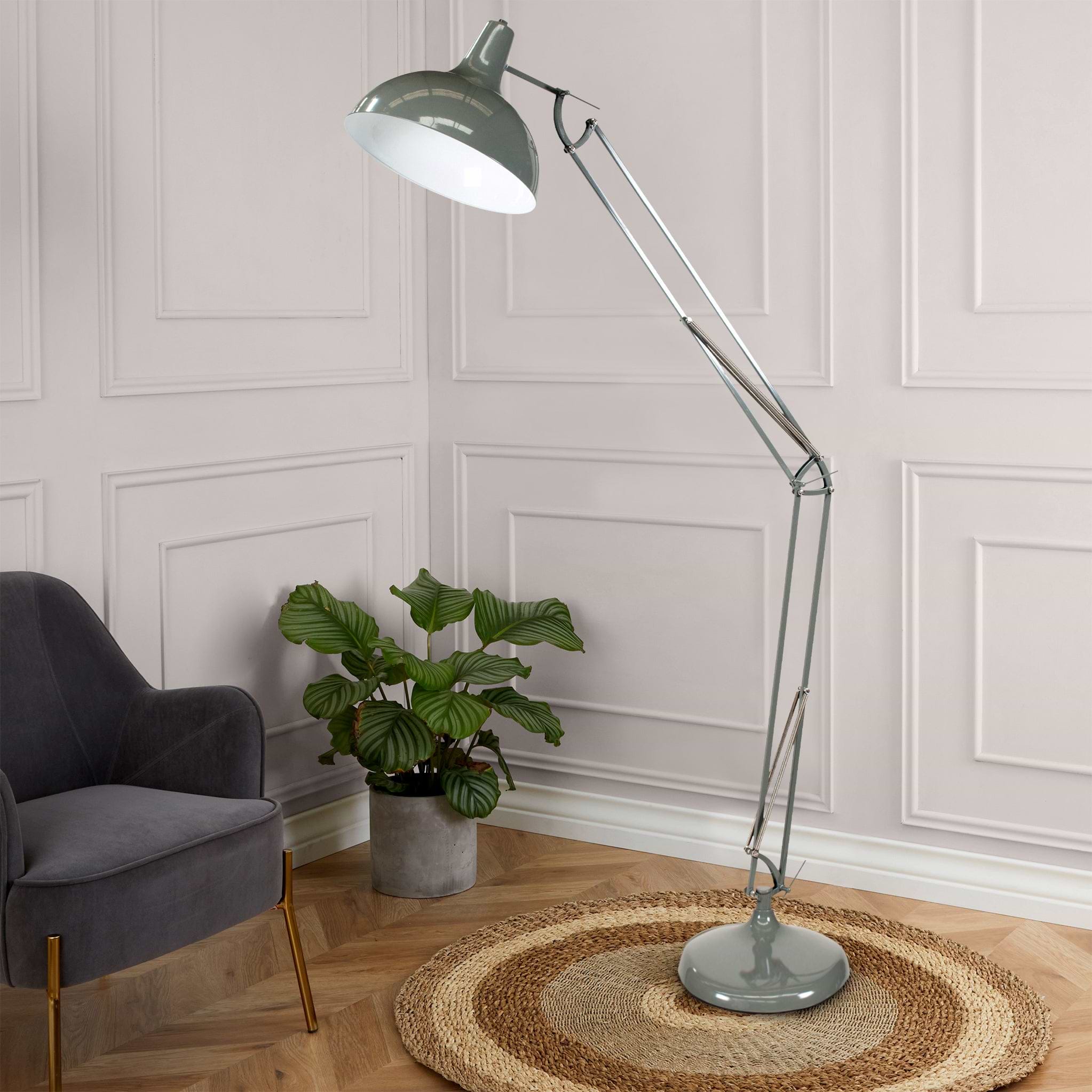 A large, adjustable floor lamp stands extended over a chair, with circular, braided rug underneath; a potted plant adds life to the elegant, paneled room.