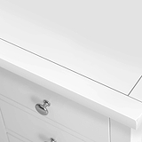 A white bathroom vanity with a closed drawer and silver knob, set against a plain background.