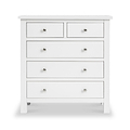 A white wooden chest of drawers with silver knobs stands against a plain background; two small upper drawers flank a third, above three larger drawers.