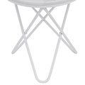 A white circular table with crossed metal legs stands against a solid neutral background, likely indicative of a product showcase or minimalist design.