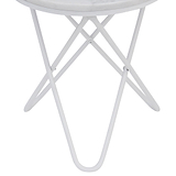A white circular table with crossed metal legs stands against a solid neutral background, likely indicative of a product showcase or minimalist design.