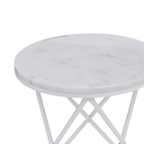 A round table with a marble top and white metal legs stands idle against a blank background.