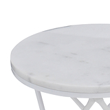 A round white marble tabletop with a partial view of its sleek metal base, isolated against a light background.