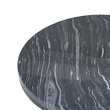 A circular black marble table top with distinctive white and gray striations, isolated against a white background.
