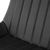 A close-up view of a black, faux-leather car seat with stitched vertical lines, against a nondescript background.