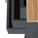 A close-up of a black angular structure adjacent to a wooden surface, possibly furniture, against a blurred background.