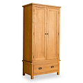 A wooden wardrobe stands isolated against a white background, featuring two doors and a lower drawer.