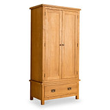 A wooden wardrobe stands isolated against a white background, featuring two doors and a lower drawer.