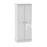 A white, freestanding wardrobe with closed double doors stands isolated against a plain, light background.